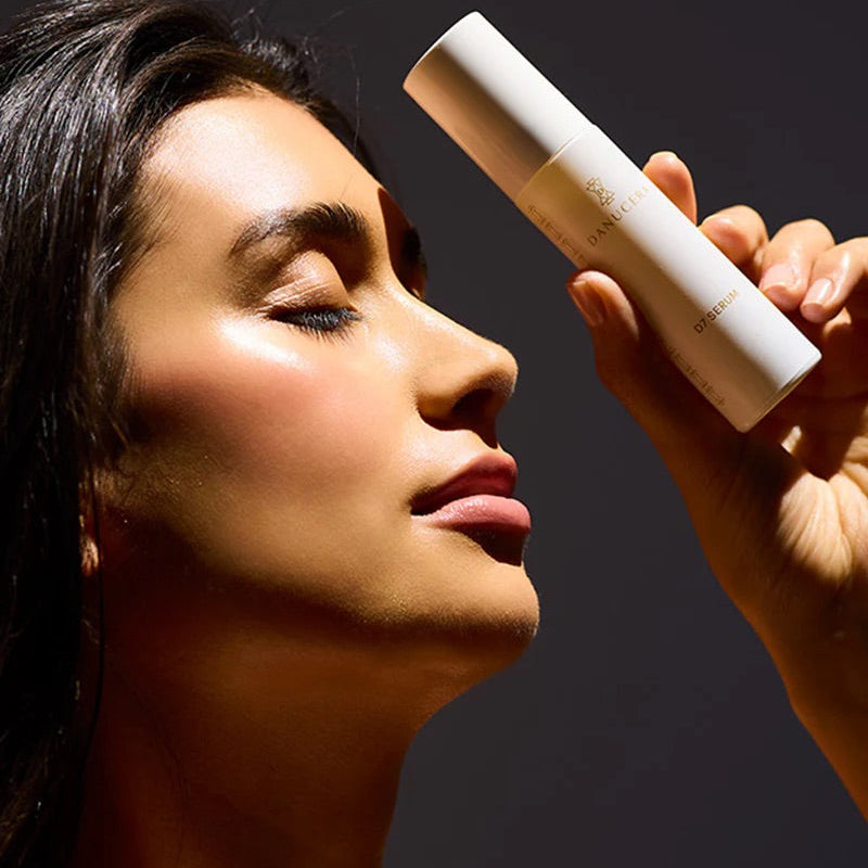 Woman holding a white bottle close to her face against a dark background