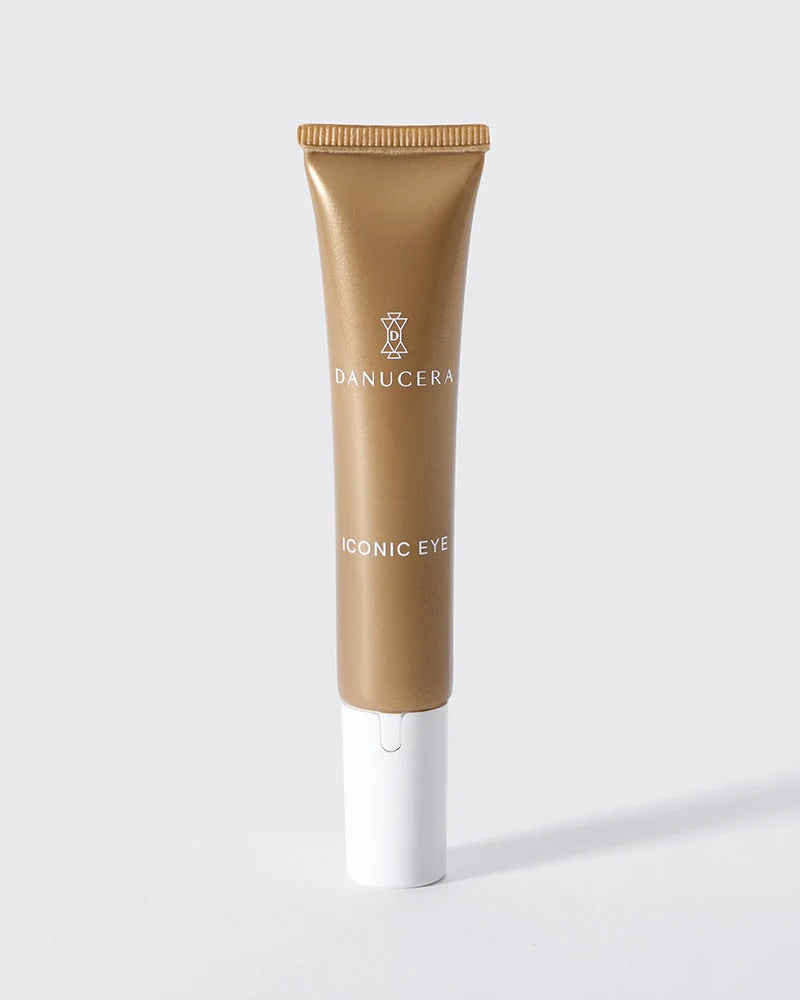 Danucera Iconic Eye cream in a metallic gold squeeze tube with a white cap, set against a clean light gray background.
