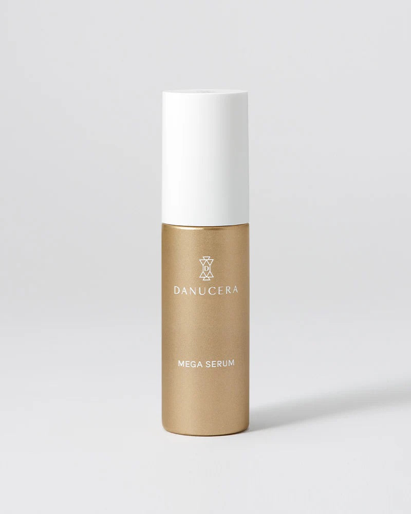 A Danucera Mega Serum bottle with a metallic gold lower body and a white cap, set against a clean light gray background.